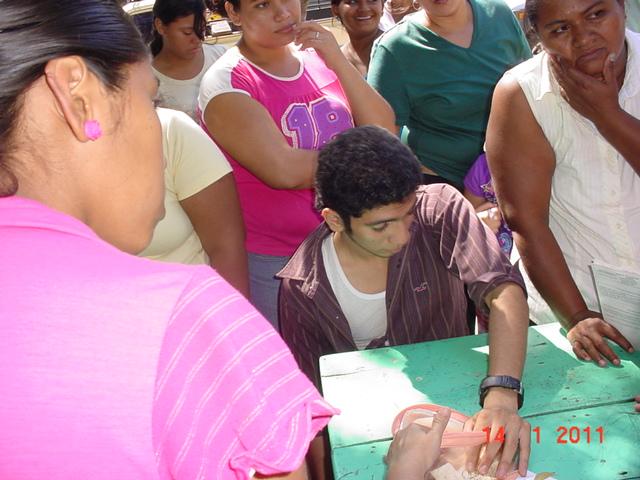 El joven Marlon Cermeño U, ayuda en la entrega de mochilas